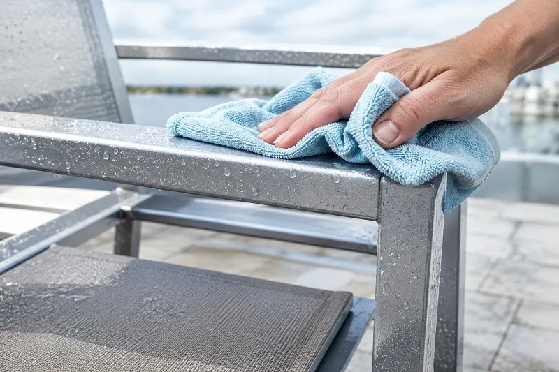 Cleaning a metal chair by the water